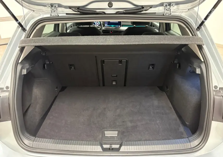Vue arrière du coffre ouvert d'une Volkswagen Golf 1.5 TSI 116 BVM6 VW Edition en argent Dolomite, intérieur noir.