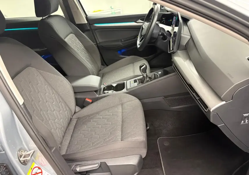 Intérieur avant droit de la Volkswagen Golf 1.5 TSI 116 BVM6 VW Edition 2025 avec sièges tissu gris et console centrale moderne