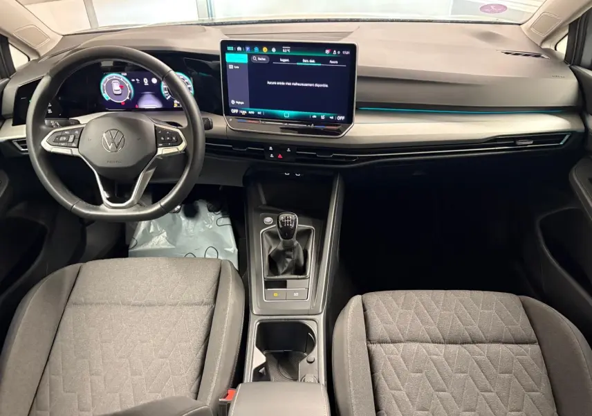 Intérieur de la Volkswagen Golf 1.5 TSI 2025, tableau de bord moderne avec écran tactile et boîte manuelle au centre.