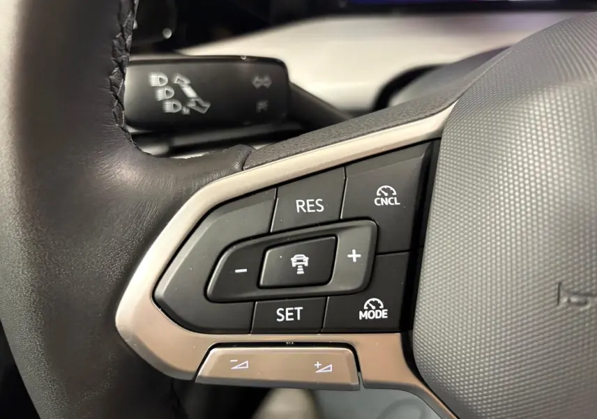 Gros plan sur les commandes du régulateur de vitesse au volant d'une Volkswagen Golf 1.5 TSI 2025.