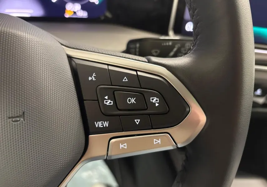 Gros plan sur les commandes multifonctions du volant en cuir noir de la Volkswagen Golf 1.5 TSI 2025.
