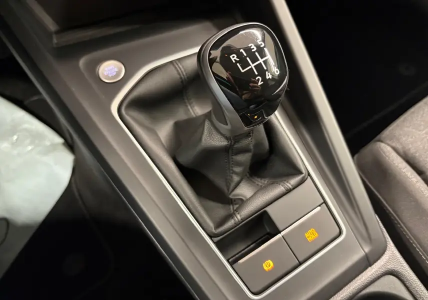 Le levier de vitesses manuel noir de la Volkswagen Golf 1.5 TSI 116 BVM6 VW Edition, vue en gros plan sur la console centrale.