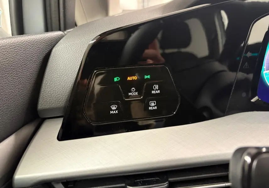 Panneau de commande des phares et dégivrage sur le tableau de bord intérieur de la Volkswagen Golf 1.5 TSI 2025.