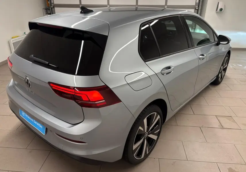 Vue 3/4 arrière droite d'une Volkswagen Golf 2025 argent Dolomite avec jantes alliage léger 18'' Catania.