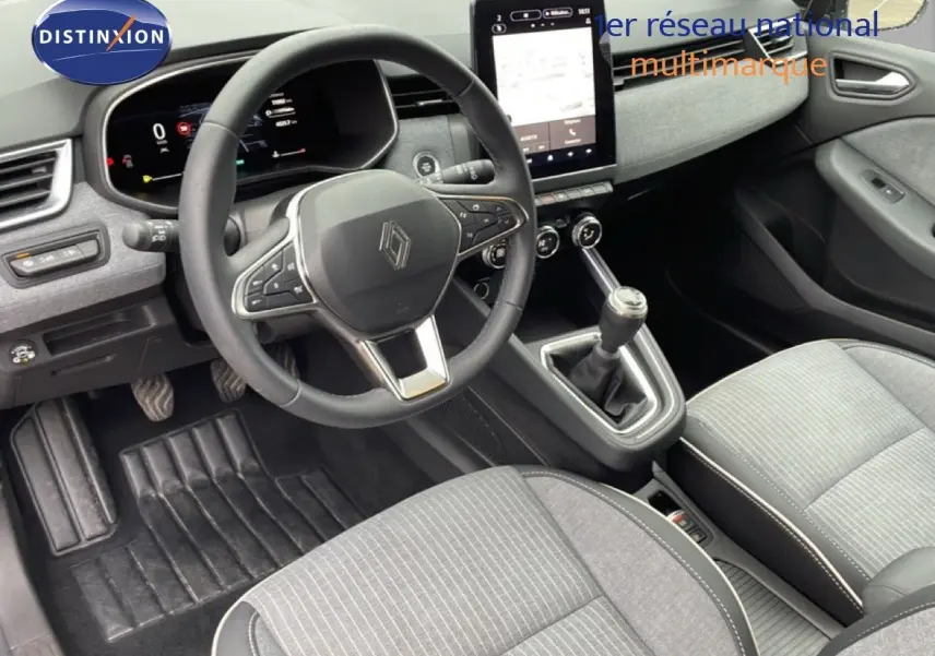 Vue intérieure côté conducteur de la Renault Clio 2025 gris schiste, volant cuir, écran tactile vertical et boîte manuelle.