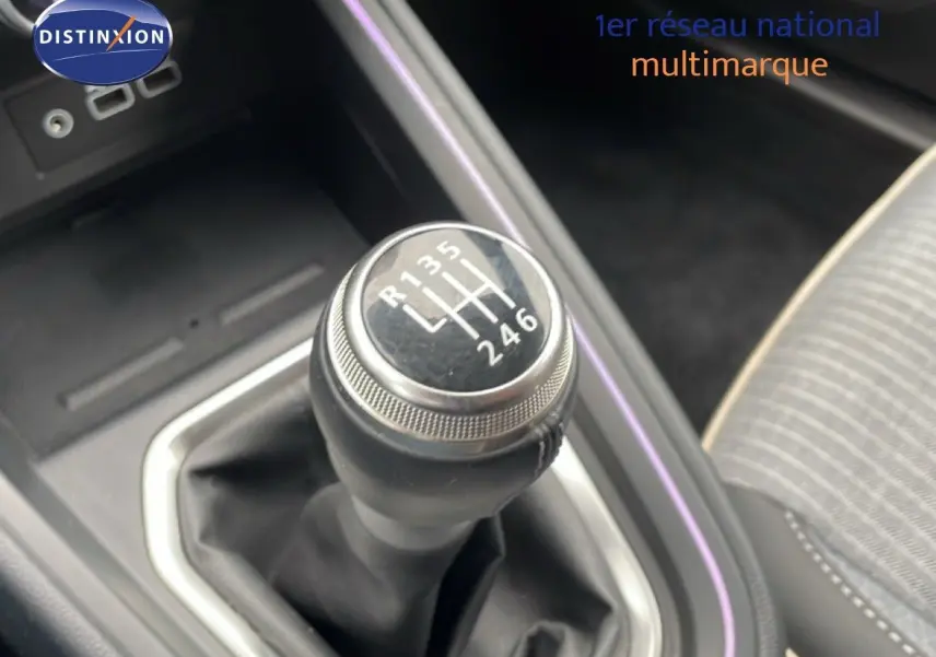 Gros plan sur le levier de vitesses manuel de la Renault Clio 2025, intérieur gris avec surpiqûres et éclairage d'ambiance violet.