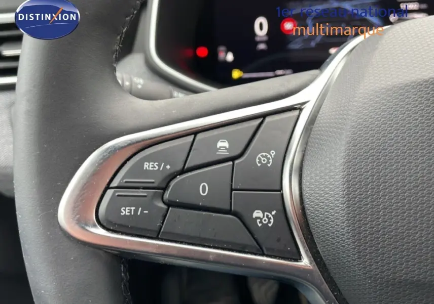 Gros plan sur les commandes au volant côté gauche de la Renault Clio 2025 gris schiste métal avec régulateur de vitesse.