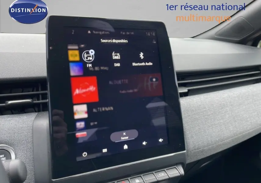 Vue intérieure centrée sur l'écran tactile multimédia de la Renault Clio 2025, avec tableau de bord gris et détails modernes.