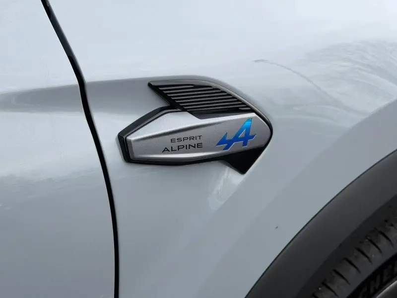 Gros plan sur l'aile avant droite gris Rafale du Renault Captur 2026 avec logo Esprit Alpine bleu et noir étoilé.