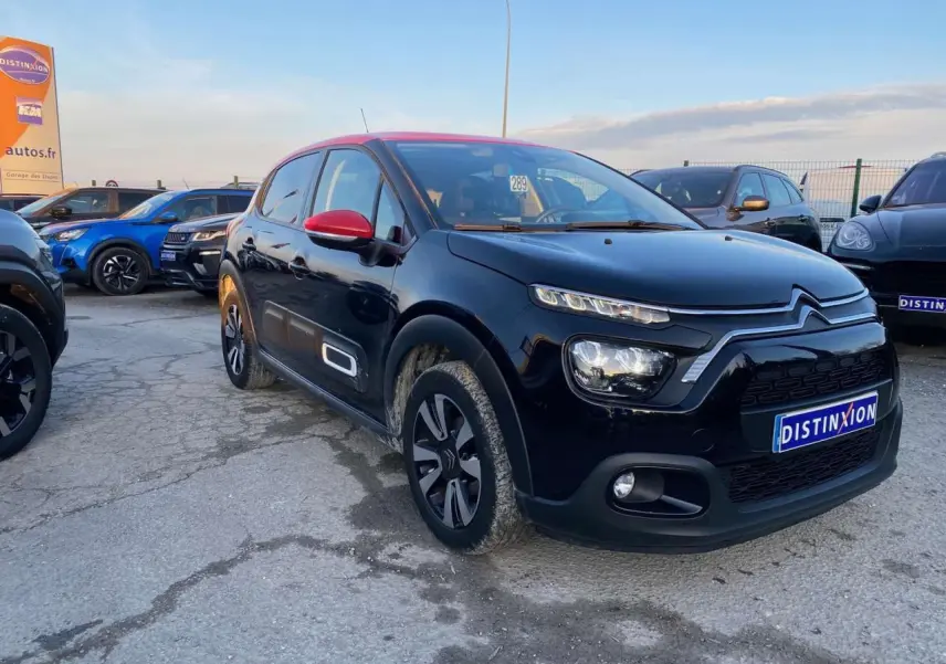 Citroën C3 Shine 2023 noir avec toit et rétroviseurs rouges, vue 3/4 avant droit en extérieur.