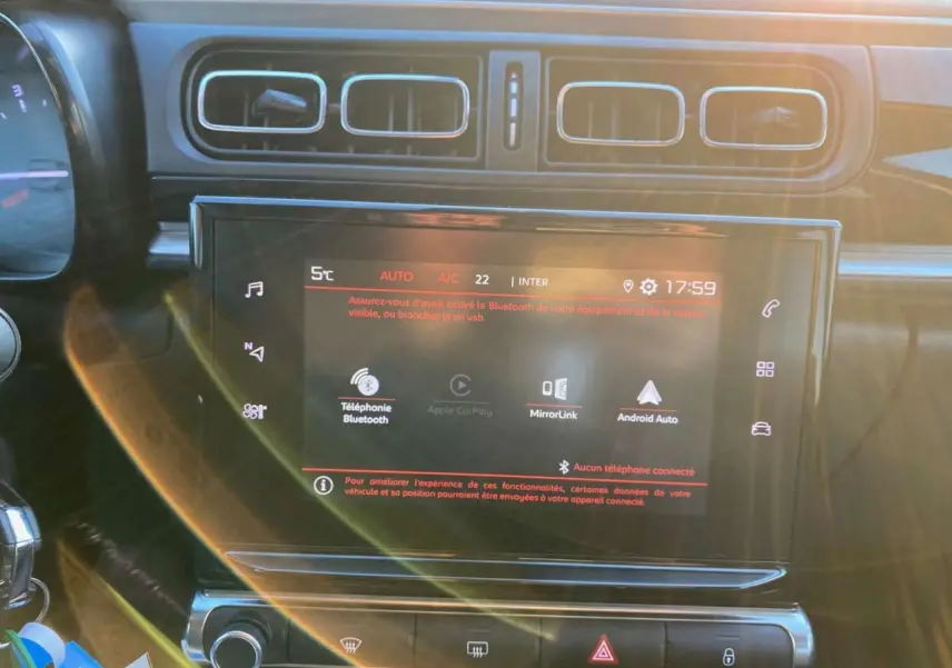 Vue rapprochée de l’écran tactile central et des aérateurs du tableau de bord de la Citroën C3 Shine 2023 noir toit rouge.