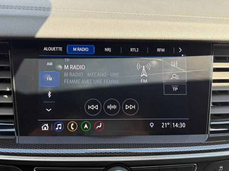 Écran tactile central de l’Opel Insignia Grand Sport 2021 affichant la radio FM avec interface moderne et finition carbone.
