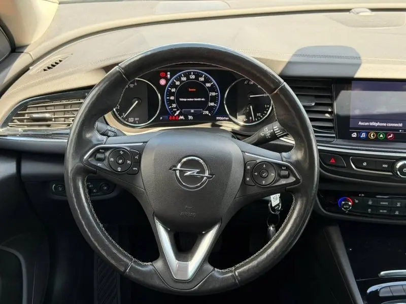 Vue intérieure centrée sur le volant cuir multifonction de l'Opel Insignia Grand Sport avec tableau de bord et écran tactile.