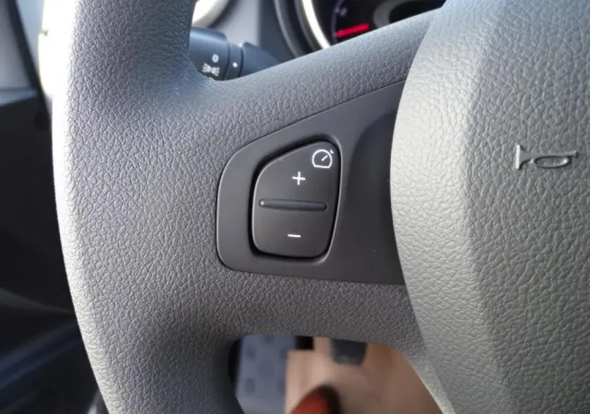 Gros plan sur le volant gris du Fiat Talento Fourgon 2020, montrant les commandes de régulation d’éclairage.