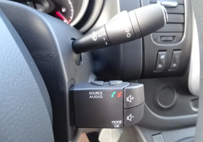 Gros plan sur la commande audio au volant du FIAT Talento Fourgon blanc, côté gauche du tableau de bord.