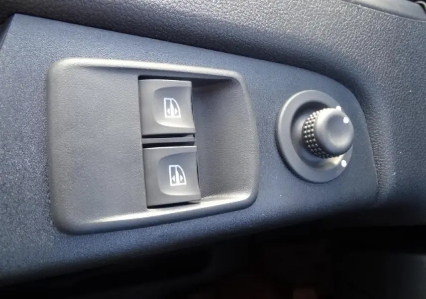 Gros plan sur les commandes de lève-vitres électriques et réglage des rétroviseurs du Fiat Talento Fourgon blanc.