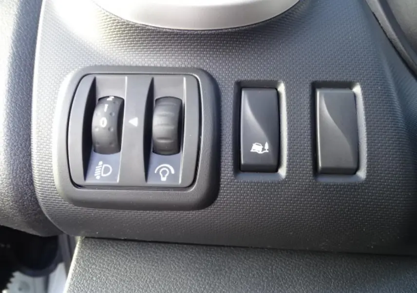 Gros plan sur les commandes de réglage des phares et de l’aide à la montée dans un Fiat Talento Fourgon blanc.