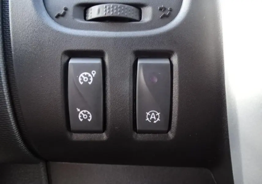 Gros plan sur les boutons de régulateur de vitesse et arrêt automatique du moteur du Fiat Talento Fourgon blanc.