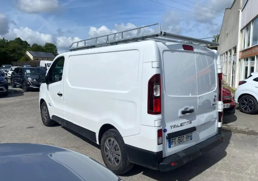Vue 3/4 arrière droite d’un FIAT Talento Fourgon blanc avec galerie de toit et portes arrière tôlées ouvertes à 180°.
