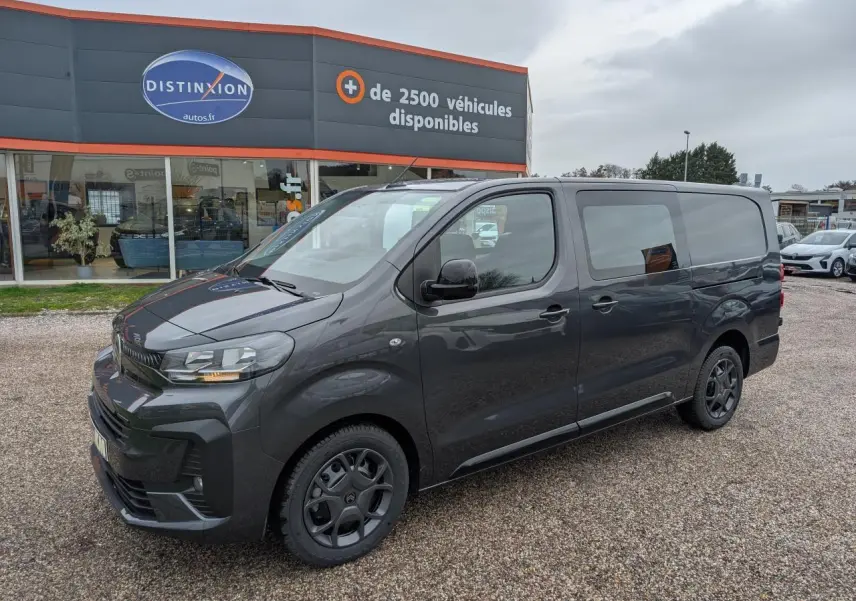 Vue 3/4 avant droit d’un Citroën Jumpy XL gris métallisé avec baguettes latérales noires et jantes tôles peintes.