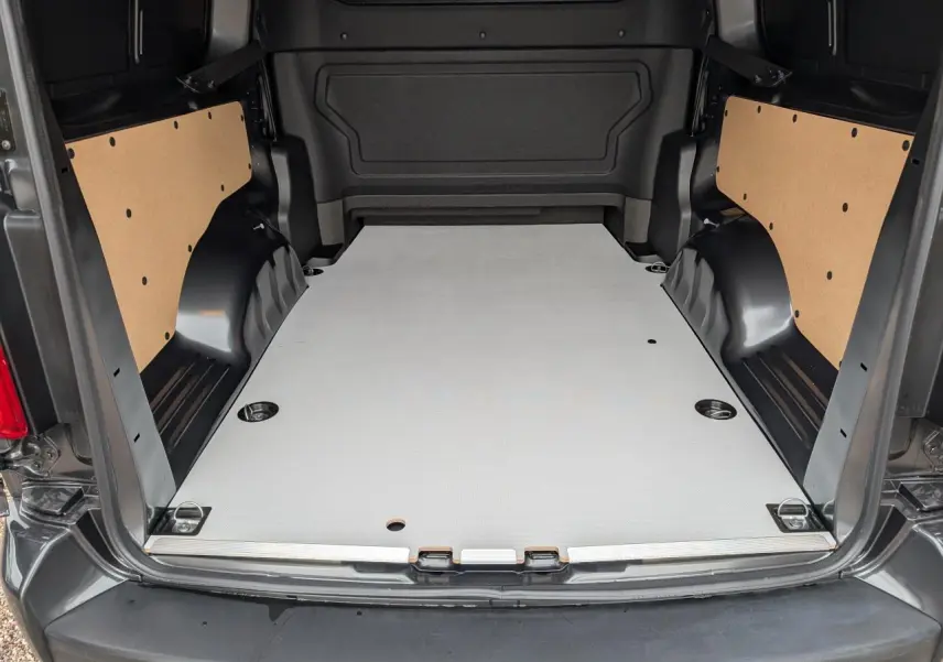 Vue arrière du Citroën Jumpy gris 2025, plancher bois clair et panneaux latéraux en bois brut visibles dans l'espace de chargement.