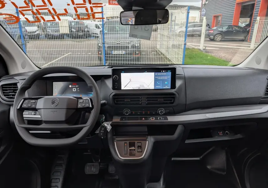 Vue intérieure avant du tableau de bord gris foncé du Citroën Jumpy XL 2025 avec écran tactile et volant multifonction.
