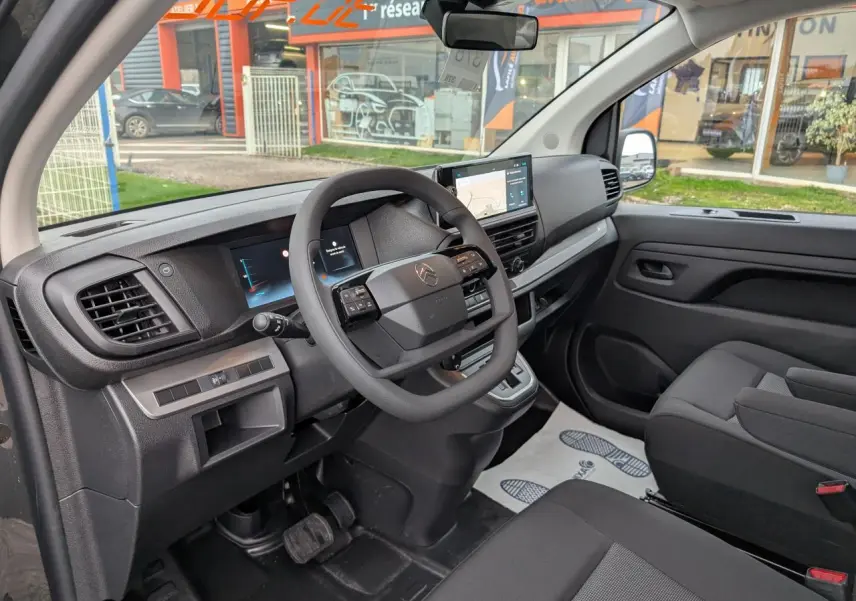Vue intérieure côté conducteur du Citroën Jumpy XL 2025, tableau de bord noir avec écran tactile et volant multifonction.