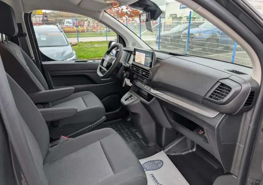 Vue intérieure côté droit du poste de conduite du Citroën Jumpy gris 2025 avec tableau de bord moderne et sièges tissu bi-ton.