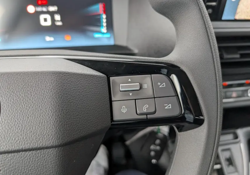 Gros plan sur les commandes audio et téléphone au volant du Citroën Jumpy gris, côté gauche.