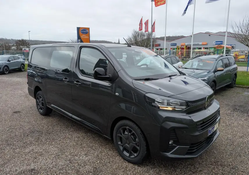 Vue 3/4 avant droit d’un Citroën Jumpy XL gris métallisé avec boucliers couleur carrosserie et coques de rétroviseurs noires.