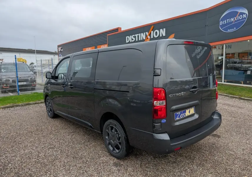 Vue 3/4 arrière droite d’un Citroën Jumpy gris avec boucliers teintés et jantes tôles noires.