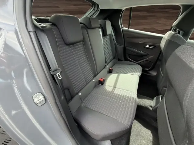 Vue intérieure arrière côté gauche de la Peugeot 208 100CH S&S Active gris foncé, banquette 3 places avec ceintures visibles.