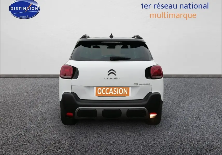 Vue arrière d'un Citroën C3 Aircross blanc polar avec feux arrière rouges et pare-chocs noir contrastant.