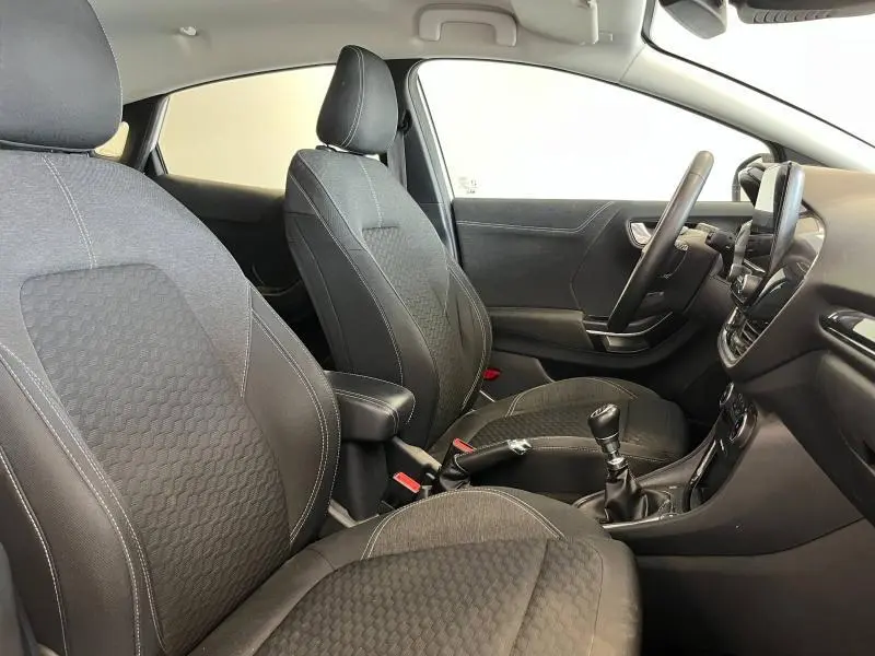 Intérieur noir de la Ford Puma 2022, vue côté droit sur les sièges avant et la console avec boîte manuelle.