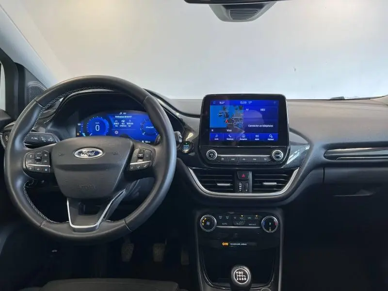 Vue intérieure frontale du tableau de bord et volant noir du Ford Puma 2022 avec écran tactile et instrumentation numérique bleue.