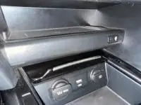 Vue intérieure du coffre de la Kia Xceed 1.6 GDI 141 Premium hybride rechargeable blanc, avec commandes et rangements visibles.