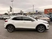 Profil droit d'un KIA Xceed blanc 1.6 GDI hybride rechargeable 2021, avec jantes alliage et toit panoramique visible.