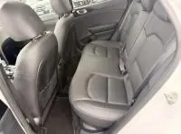 Intérieur arrière côté droit de la Kia Xceed 1.6 GDI hybride rechargeable blanche, sièges en cuir gris et espace passagers visible.