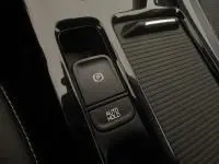 Gros plan sur la commande de frein à main électrique et bouton Auto Hold dans l'habitacle du Kia Xceed blanc hybride rechargeable.
