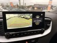Écran intérieur montrant la caméra de recul d'une KIA Xceed blanche 2021 hybride rechargeable, vue depuis le tableau de bord.
