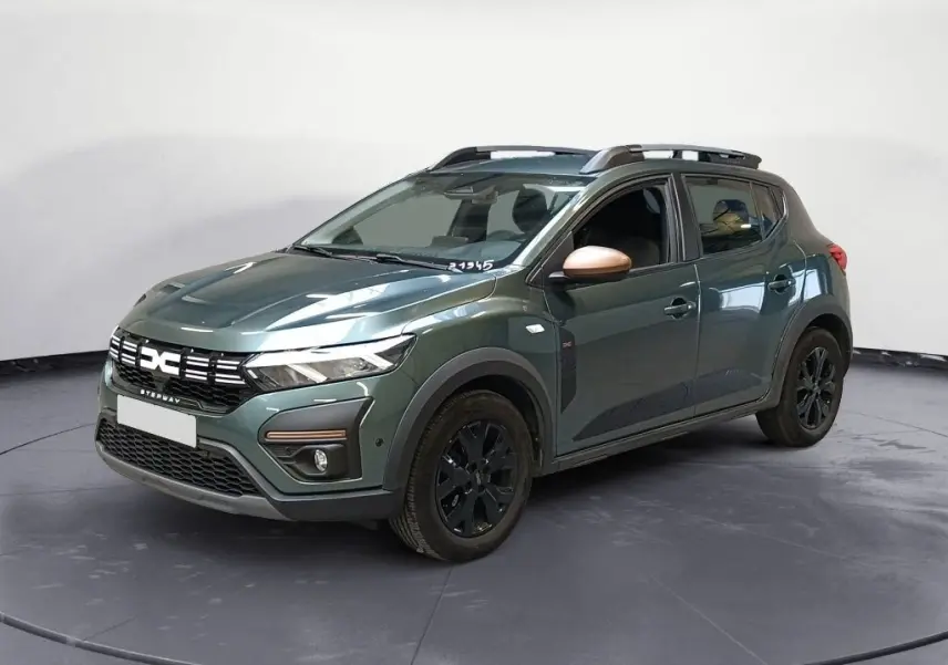 Vue 3/4 avant droit d'une Dacia Sandero Stepway 2024 vert cèdre avec jantes noires et rétroviseurs brun cuivré.