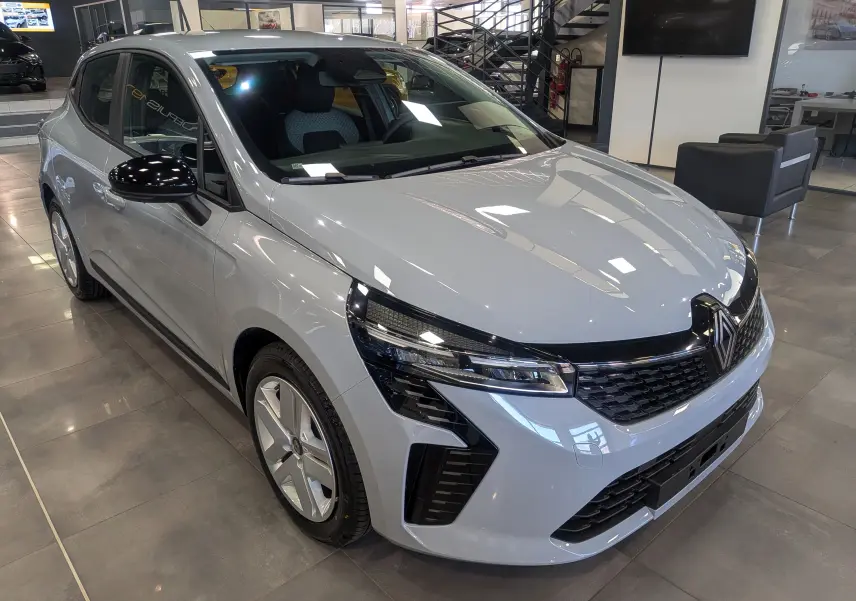 Renault Clio V Blue dCi 100 gris Rafale vue 3/4 avant droit en intérieur, avec calandre noire et jantes alliage.