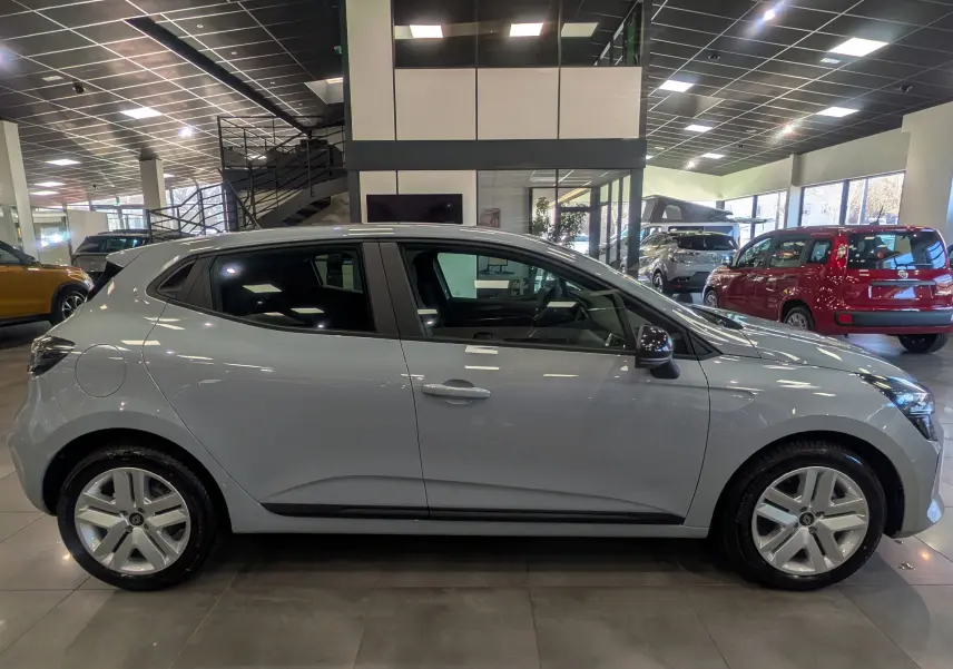 Renault Clio V Blue dCi 100 gris Rafale vue de profil côté gauche en intérieur de showroom lumineux.