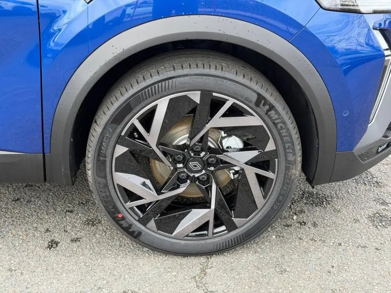 Gros plan sur la roue avant droite du Renault Captur 2026 Bleu Iron/Noir Étoilé avec jante au design géométrique noir et argent.