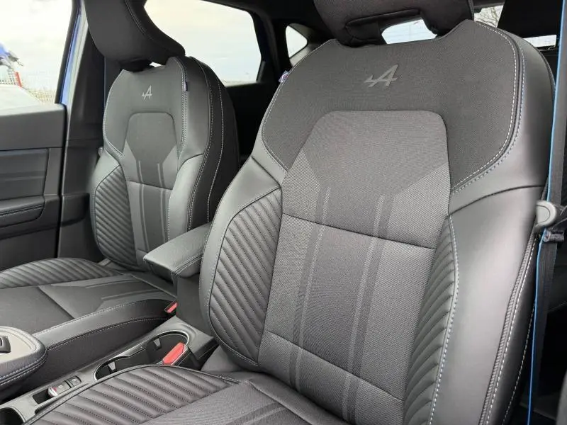 Gros plan sur les sièges avant noirs du Renault Captur 2026 esprit Alpine avec logo brodé et surpiqûres contrastées.