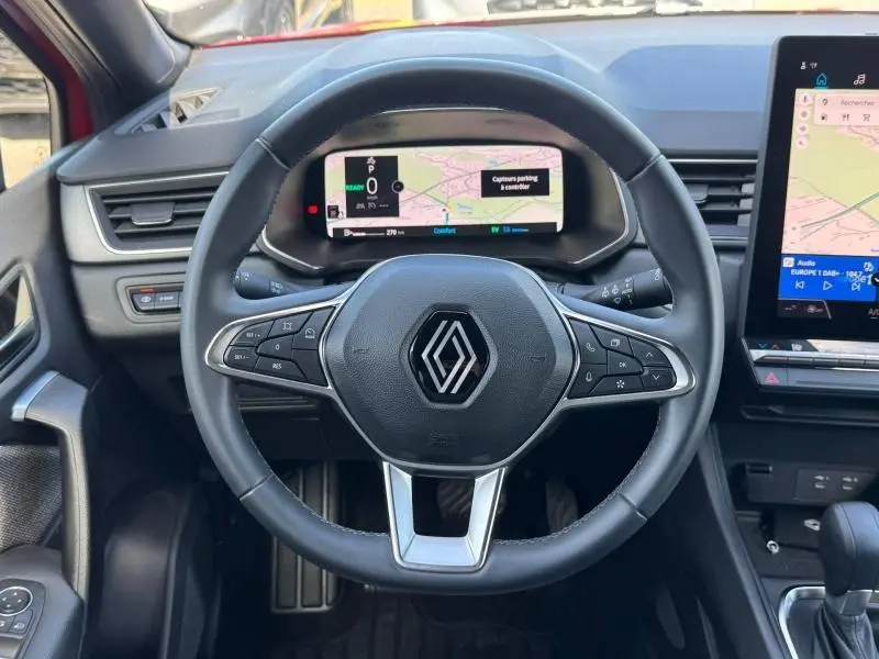 Vue centrée sur le volant multifonction noir du Renault Captur 2025 avec écran numérique et console tactile à droite.