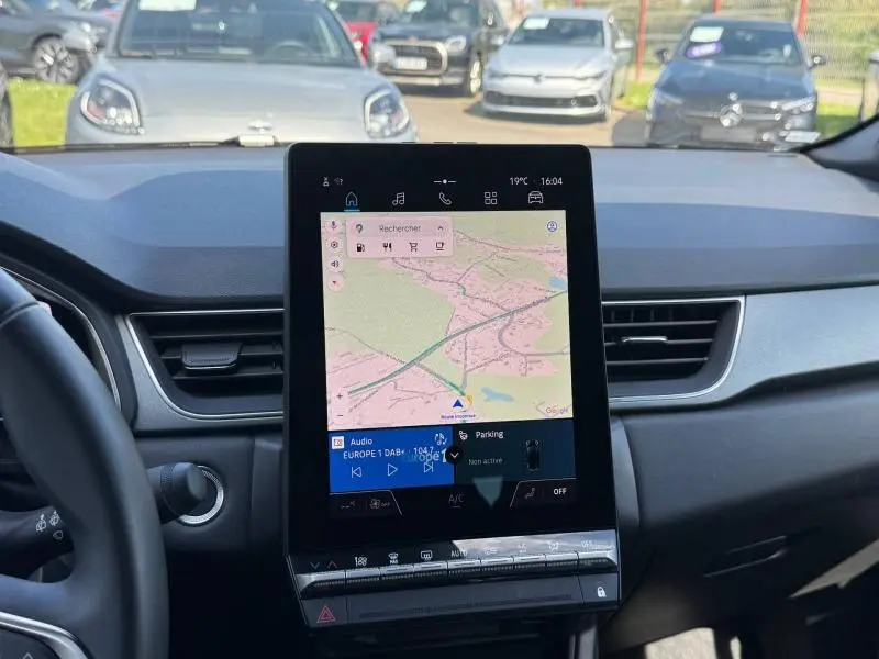 Vue intérieure centrée sur l'écran tactile vertical du tableau de bord du Renault Captur 2025, avec navigation affichée.