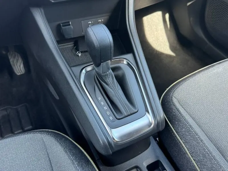 Gros plan sur la console centrale du Renault Captur 2025, levier de boîte auto entouré de garnitures noires et argentées.
