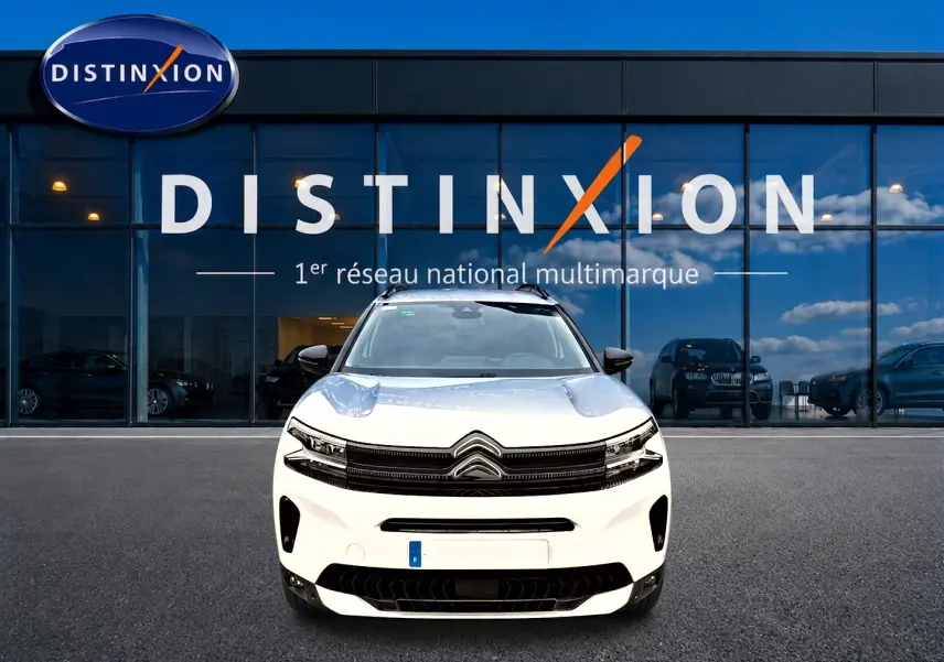 Citroën C5 Aircross blanc vue de face devant une vitrine avec logo Distinxion en arrière-plan.