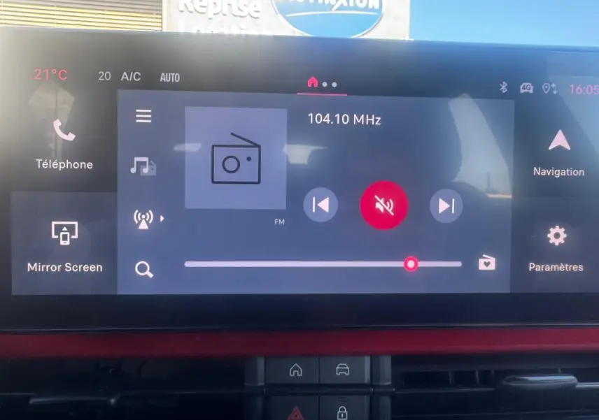 Écran tactile central de la FIAT 600 rouge, vue intérieure du tableau de bord avec interface multimédia affichée.